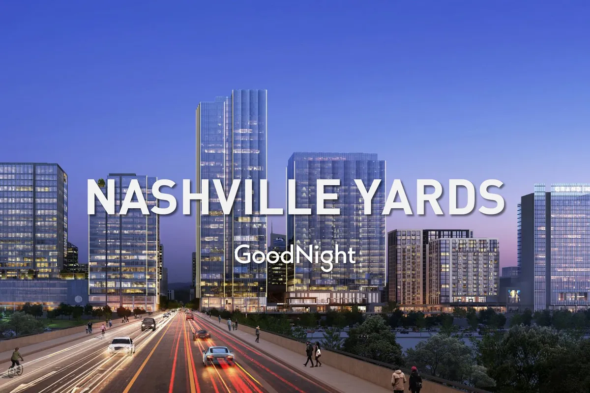 A striking view of modern skyscrapers comprising the Nashville city skyline, with vibrant city lights and bustling traffic below. The energetic street scene highlights Nashville’s dynamic business district, suggesting proximity to major venues, hotels, and companies such as Amazon HQ2 and Music City Center.